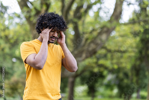 Photography Close-up photo of a young Indian sportsman standing in the park and holding his