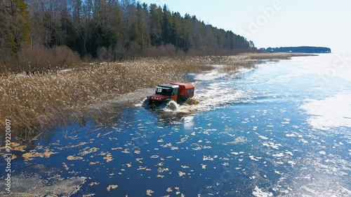 A four-wheel-drive car driving on water. Winter Wanderer. Off-Road Master of the Arctic Tundra. Aerial Drone shot