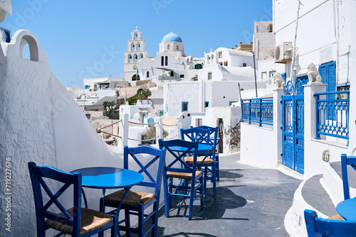 Typical street with blue tables and chairs among white houses on the Greek island of Santorini, Pyrgos village. Greek Islands, European Vacation. Travel, holidays, relax, adventure.