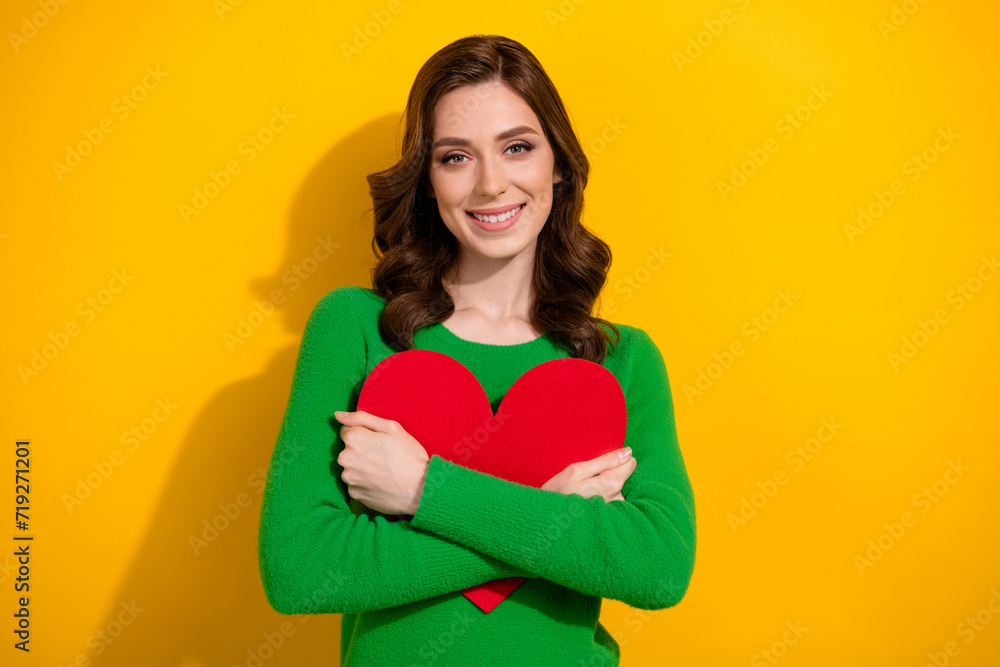 Photo of pretty cute woman dressed green stylish clothes hold red paper postcard celebrate holiday isolated on yellow color background Photo of pretty cute woman dressed green stylish clothes hold red paper postcard celebrate holiday isolated on yellow color background