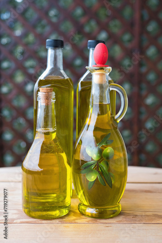 olive oil  extra virgin olive oil in a glass bottle  on a wooden table. extra virgin olive oil  from organic olive groves in Greece  genuine taste of oil from the Mediterranean.  