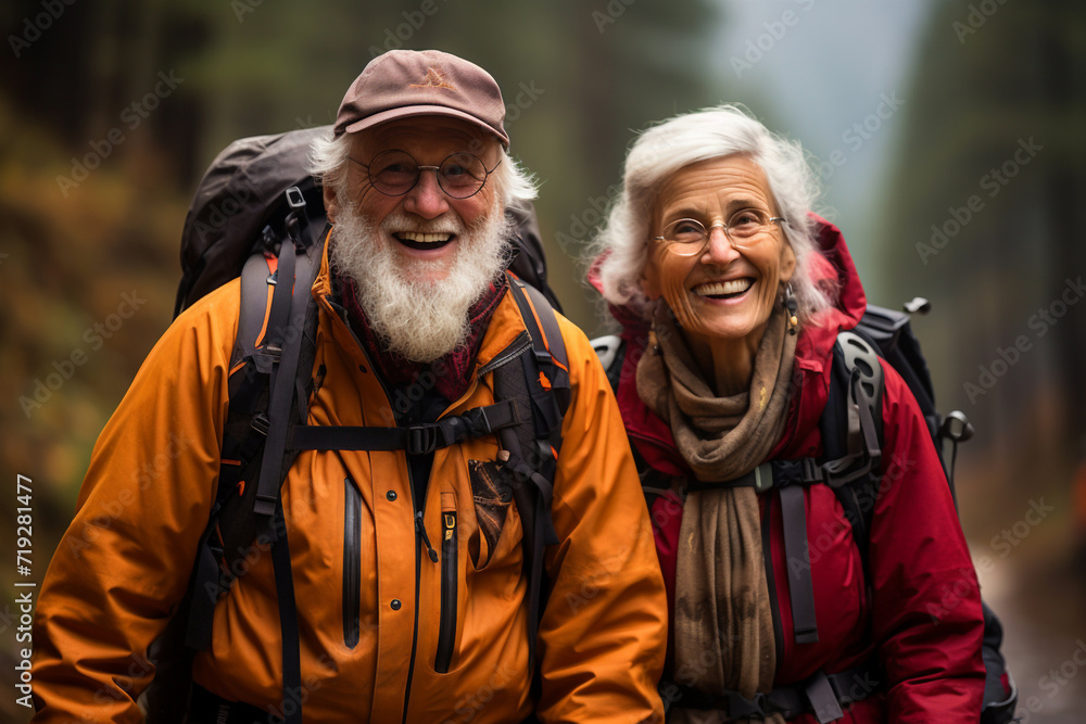 Senior cheerful active smiling mature couple trekking hiking take selfie, look happy in park in autumn sea view sunlight day time, happily retired. Energetic and elderly healthy lifestyle concept.