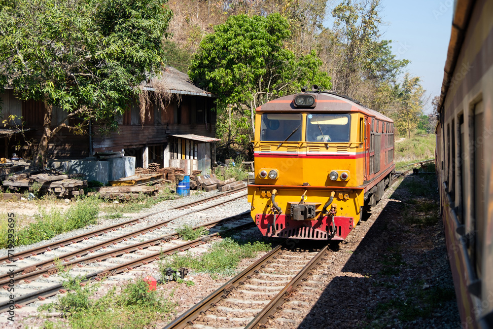 The diesel electric locomotive is parked at a small train station. The diesel electric locomotive is parked at a small train station.