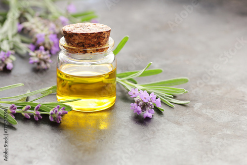 Lavender essential oil or extract in glass bottle with fresh flower and leaf on black background, closeup, spa, skin care, aroma therapy, beauty treatment concept