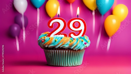 Birthday cupcake with burning lit candle with number 29. Number twentynine for twentynine years or twentynineth anniversary.