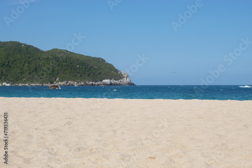 paradise beach located into colombian tayrona national park with tropical jungle and blue sky at background
