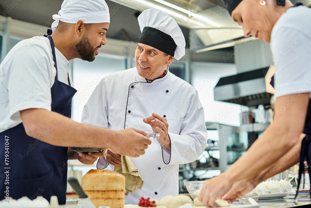 cheerful mature chief cook in white hat explaining information joyfully to his multiracial chefs cheerful mature chief cook in white hat explaining information joyfully to his multiracial chefs