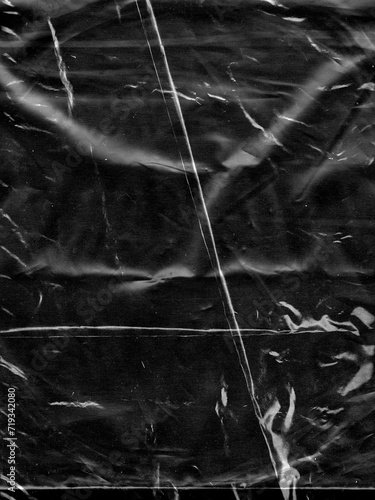 Wrinkled plastic wrap texture on a black background