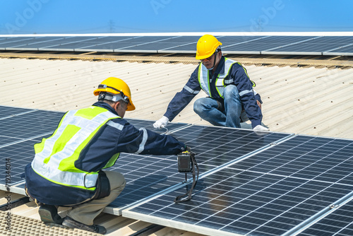 engineer men inspects construction of solar cell panel or photovoltaic cell at roof top. Industrial Renewable energy of green power. factory at urban area. worker working on tower roof.
