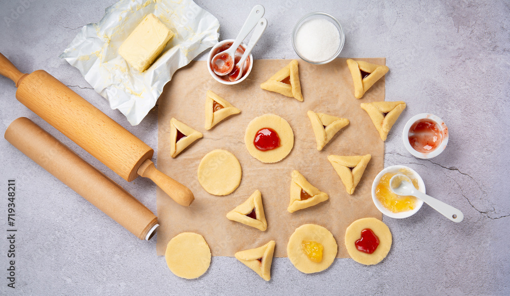 Dough, Jam, Sugar, Butter, Rolling Pin on Gray Stone Table. Purim Celebration, Jewish Carnival Holiday Concept. Dough, Jam, Sugar, Butter, Rolling Pin on Gray Stone Table. Purim Celebration, Jewish Carnival Holiday Concept.