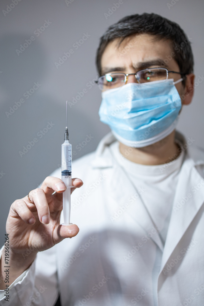Doctor holding syringe. Doctor with mask and stethoscope. Doctor holding syringe. Doctor with mask and stethoscope.
