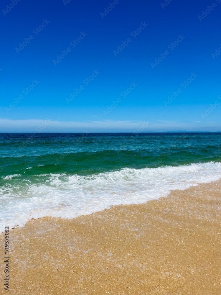 Blue seascape, sandy sea coastline, empty wild beach, pure blue sky, sea horizon