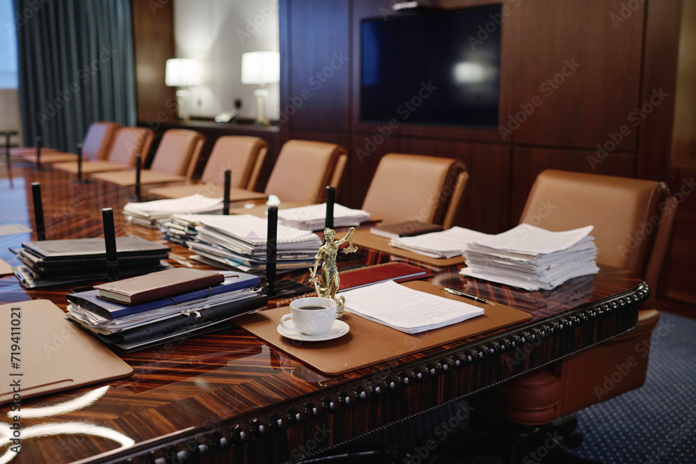 Interior of spacious conference room with modern furniture and statue of goddess of justice on table Interior of spacious conference room with modern furniture and statue of goddess of justice on table