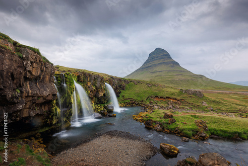 Summer landscape of Nordic nature, coastal hinterland in Iceland with picturesque valley and magnificent Kirkjufell mountain in the background