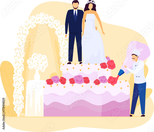 Bride and groom stand atop a huge wedding cake as chef decorates it. Pastry chef in white uniform adorning a multi-layered cake with roses.