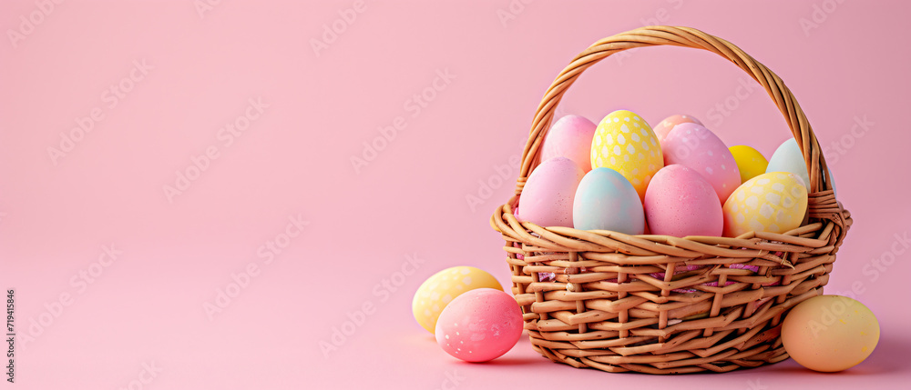 a variation of colorful easter eggs in the basket and some eggs on the floor on easter day at the right side of the frame, leaving the blank area on the left, isolated minimal pastel pink background