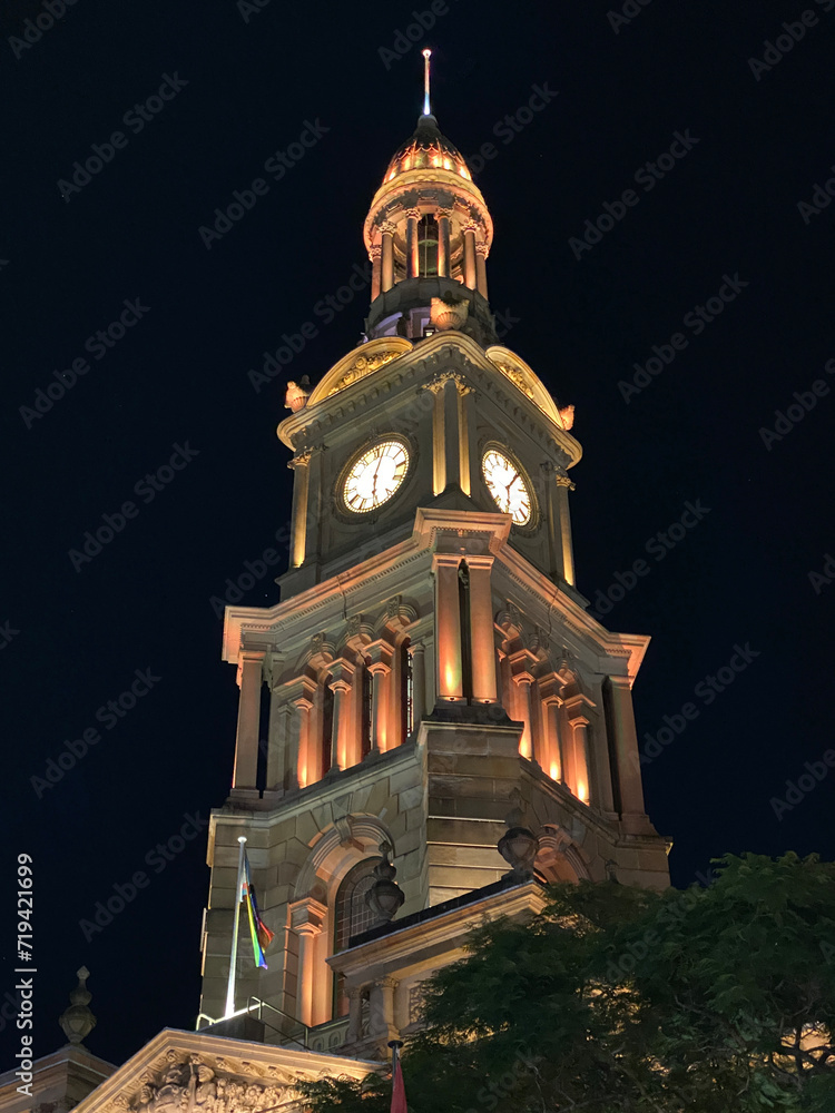 Clock tower illuminated at night. Ancient building tower against a black dark sky.