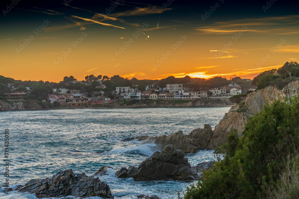 Sunset on the rocky Mediterranean sea shore. Evening at traditional Costa Brava village.