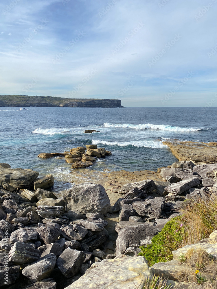 The coast of the sea. Waves curling on the rocky shore. Mountain in the ocean. View of the rocky coast of island, Australia. 