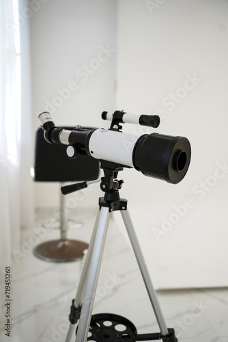 White telescope in the room with no people at morning.