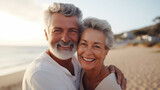 Elderly Caucasian couple hugging on the beach.