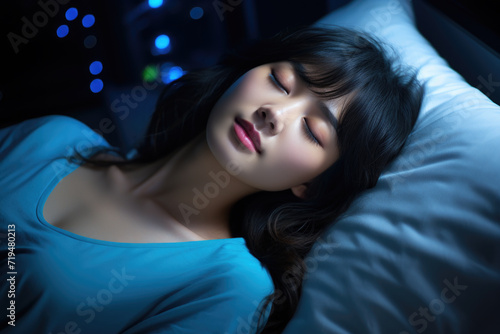 Woman is pictured laying in bed with her eyes closed. This image can be used to represent relaxation, rest, or sleep