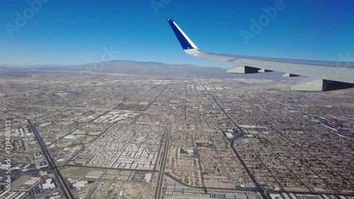 Airplane window seat flying low altitude over las vegas city usa america wing view photo