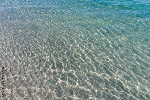 Clear water reflections on shallow sandy beach bottom. UAE Jumeirah beach.