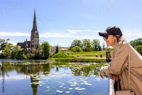 Canvas Print Portrait young beautiful happy smiling womane wear biege trench coat enjoy walking Kastellet citadel park against St