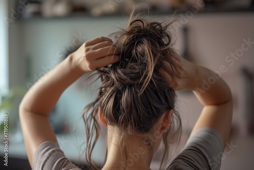 Woman Securing Her Hair Into Ponytail From The Back
