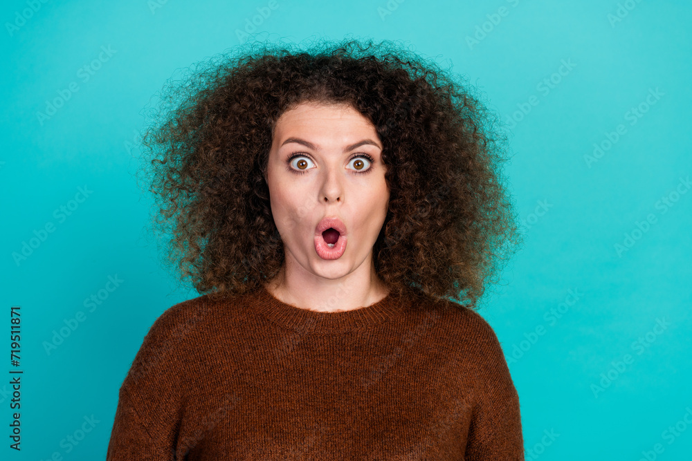 Portrait of funny girl with curly hair wearing brown sweater staring with open mouth cant stop watching isolated on cyan color background - obrazy, fototapety, plakaty 
