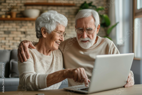 Happy family at the laptop computer. Smiling elderly senior man and woman, husband and wife photo