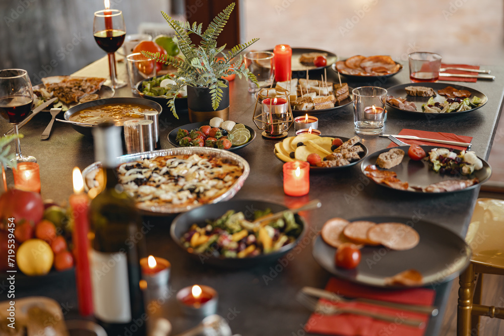Cozy holiday table setting with different delicious food and beverages ready for friends home party
