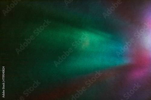 Soft Bright multicolored glare on dark rough textured cardboard. Soft rainbow light. Abstract colorful background. Colorful lens flare leak on a paper texture.