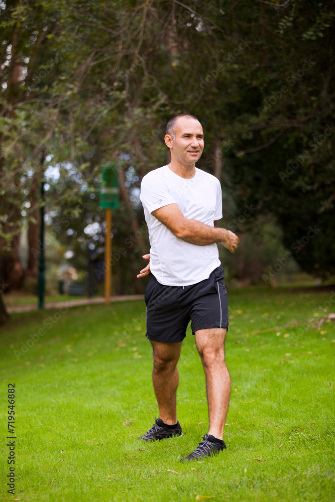 Mature man running, workout and streetching at the city park