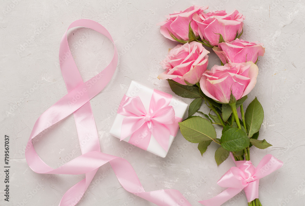 Composition with pink roses, gift box and eight made of ribbon on concrete background, top view. Women's day concept