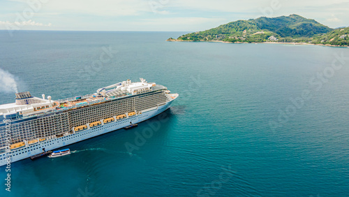 High-angle shot from a drone The largest cruise ship in Asia in front of Patong Beach, Phuket, mountain and sea atmosphere.