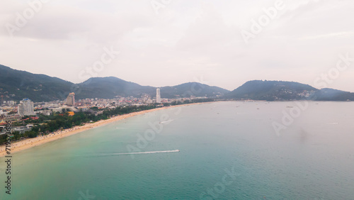 Aerial view, drone flying over Phuket city, Thailand. Drone over Patong Beach on Sunday in Phuket and tourists shopping at a street full of local merchants selling food, people resting by the sea. © Stock.Foto.Touch