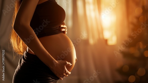 Unrecognizable young pregnant woman with big belly near window. copy space for text.