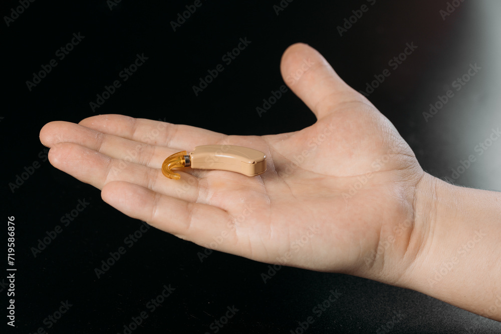 hearing aid on white background in hand, cochlear implant hearing aid on white background in hand, cochlear implant
