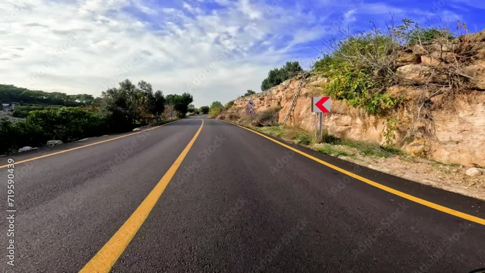 Scenic drive on mountain asphalt road, sunny day. Car travels on asphalt road in mountains, yellow lines. Mountain road journey, asphalt path under blue sky Scenic drive on mountain asphalt road, sunny day. Car travels on asphalt road in mountains, yellow lines. Mountain road journey, asphalt path under blue sky
