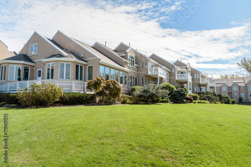 Modern low-rise apartment building surrounded by shrubbery and lawns on a sunny autumn day photo