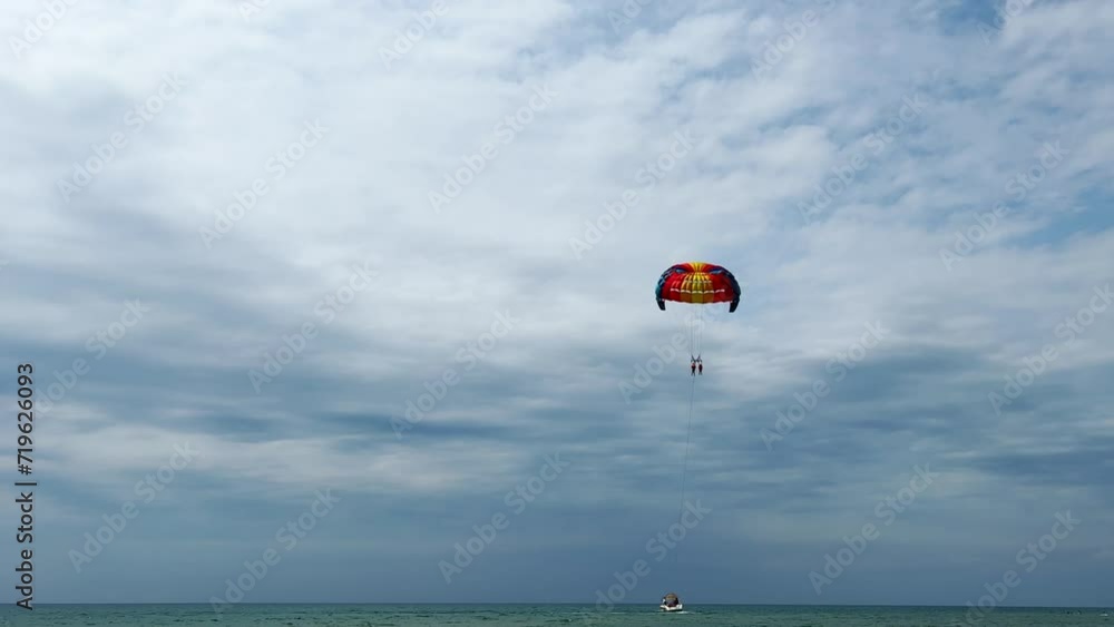 Parasailing: a boat with a marine parachute on the waves. The concept of a cloudy landscape, freedom and summer. Parachutists over the surface of the Black Sea against the sky on a summer day. 4K Parasailing: a boat with a marine parachute on the waves. The concept of a cloudy landscape, freedom and summer. Parachutists over the surface of the Black Sea against the sky on a summer day. 4K