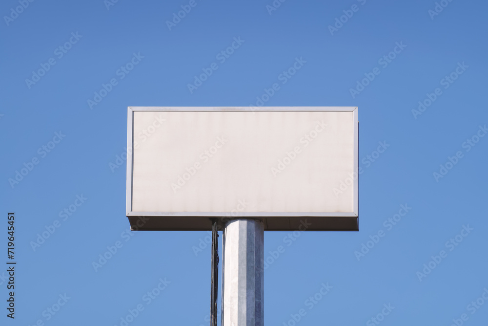 Blank faded old billboard, space for advertising text against background of blue sky Blank faded old billboard, space for advertising text against background of blue sky