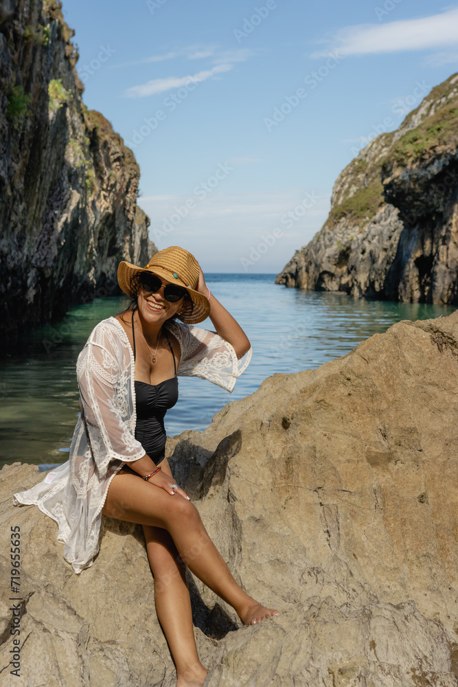 Beautiful young Latin woman, poses on a paradisiacal beach, wearing a white blouse and a straw hat Beautiful young Latin woman, poses on a paradisiacal beach, wearing a white blouse and a straw hat