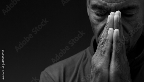 black man praying to god Caribbean man praying with black background with people stock photo	 photo