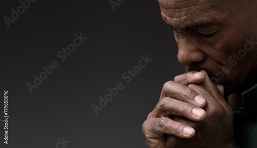black man praying to god Caribbean man praying with black background with people stock photo	