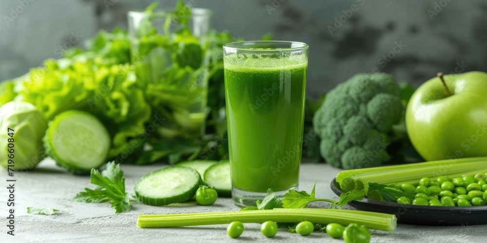 Glass of celery healthy green juice arranged with a variety of green foods Glass of celery healthy green juice arranged with a variety of green foods