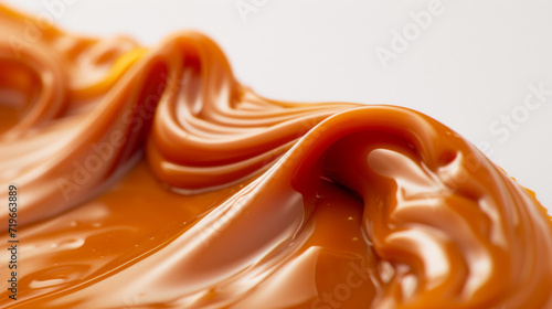 Macro photography of Flowing caramel. This versatile confection adds delicious, creamy flavor to desserts, pastries, and candies. Concept for National Caramel Day, April 5.