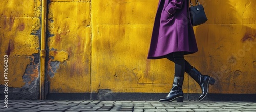 Young woman legs in black ankle boots and purple coat with bag Trendy hipster outfit. Copy space image. Place for adding text photo